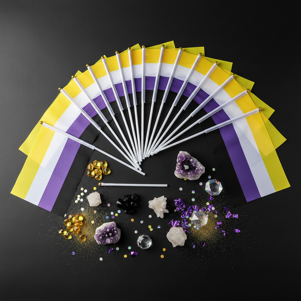Fan of non-binary pride hand flags with gems and confetti on a black background