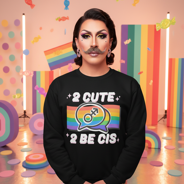 Model wearing a black sweatshirt reading “2 CUTE 2 BE CIS” with a rainbow speech-bubble graphic