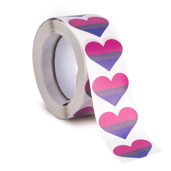 Roll of bisexual pride heart stickers, with the strip unspooling toward the viewer