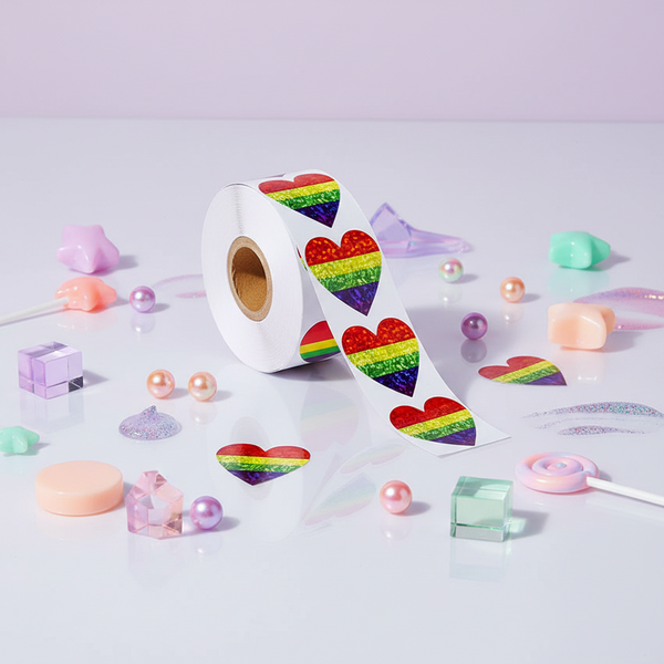 Roll of 500 LGBT Pride Heart Stickers with glittery hearts, on a glossy surface, pastel beads, iridescent decor