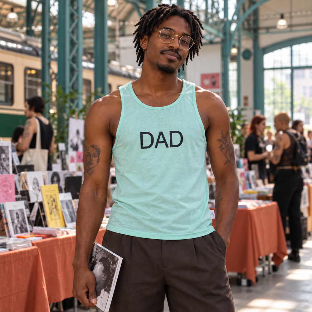 Dad Gym Sheer Tank Top in Mint Green, worn by an adult model a queer zine fair inside a converted tram depot, teal steelwork and terracotta tables.