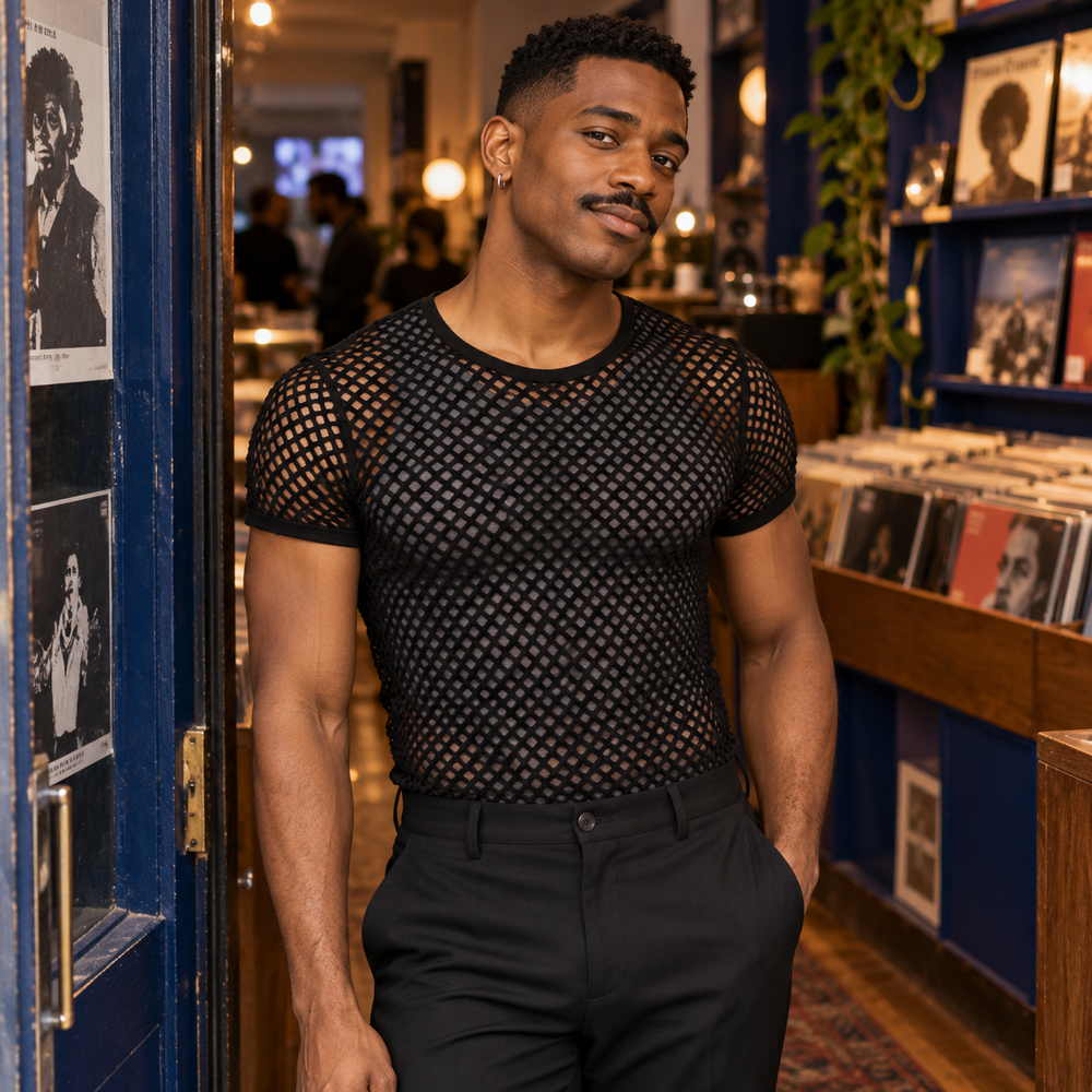 Man wearing a black short-sleeve mesh T-shirt in a record shop.