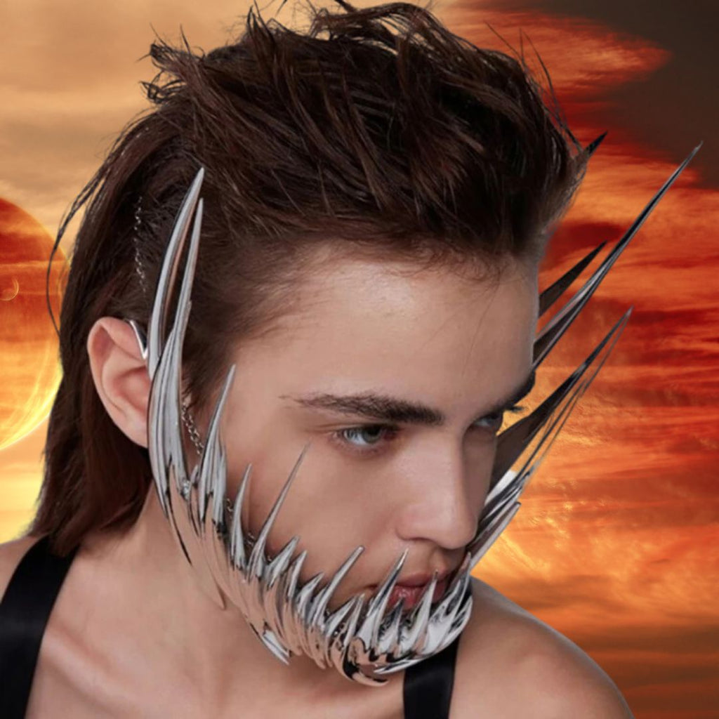 The Dystopian Dream Metal Mask, a bold, sculptural chrome-like adornment with spikes framing the jaw and cheeks, embodies queer empowerment and self-expression against a futuristic, surreal backdrop.