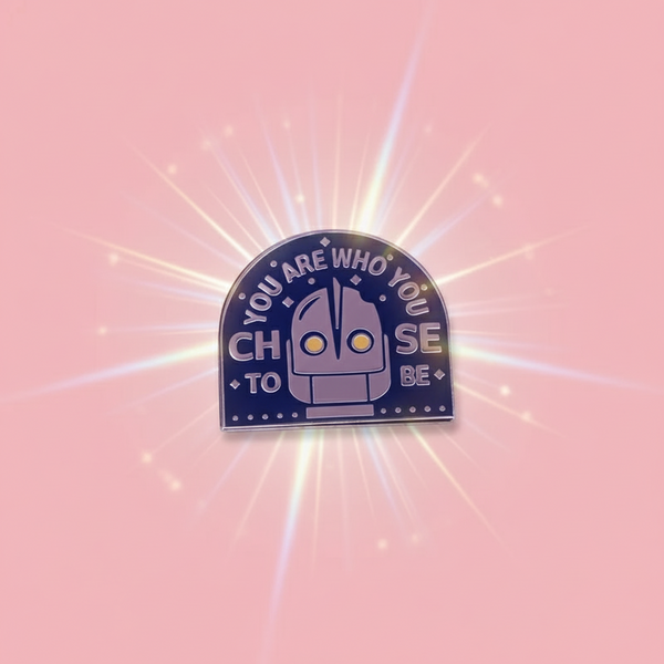 You Are Who You Choose To Be Enamel Pin features a stylized robot head with glowing eyes, surrounded by empowering text, perfect for expressing pride and self-expression with bold queer energy.