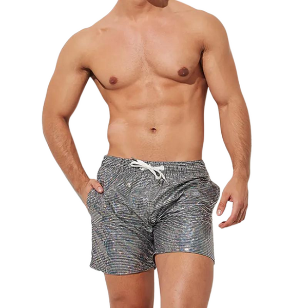 A shirtless male torso models Men's Metallic Print Sequin Casual Sporty Shorts, featuring a speckled gray pattern and a white drawstring, embodying queer pride and bold self-expression.