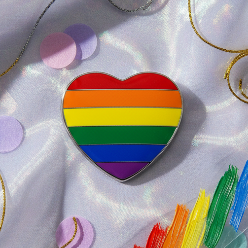 LGBT Pride Heart Badge showcases vibrant rainbow stripes on a heart-shaped pin, symbolizing pride and identity. Positioned on a shimmery backdrop, it highlights empowerment and self-expression for the LGBTQIA+ community.