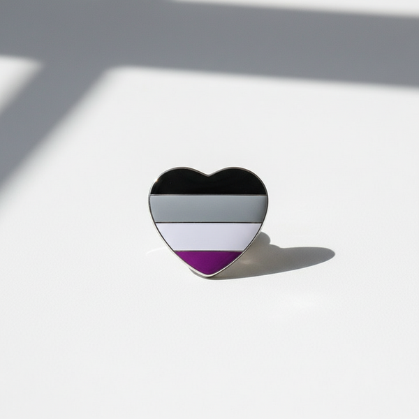 Asexual Pride Heart Badge: A vibrant heart-shaped enamel pin featuring asexual pride stripes, designed for bold self-expression and empowerment. Perfect for showcasing pride with flair and confidence.