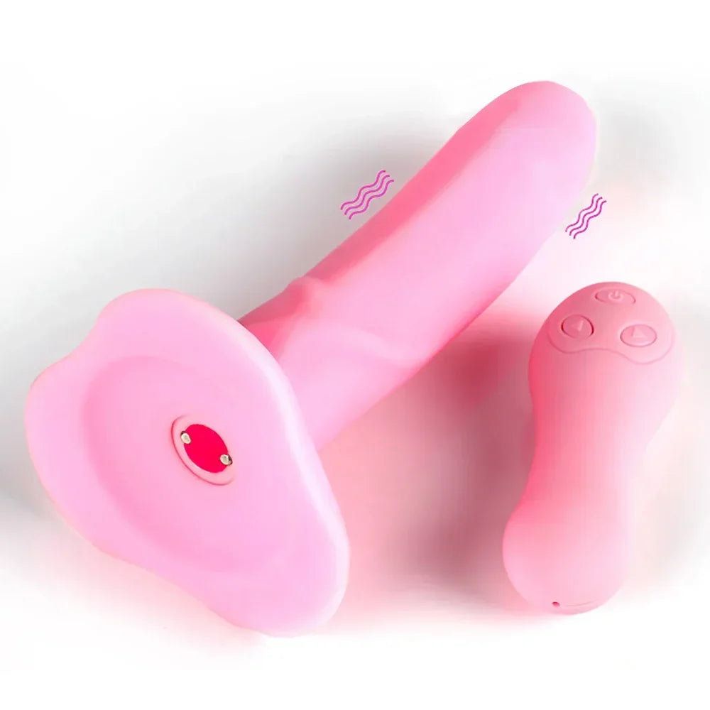 Close-up of a pink vibrating strap-on dildo with a remote control and suction-cup base