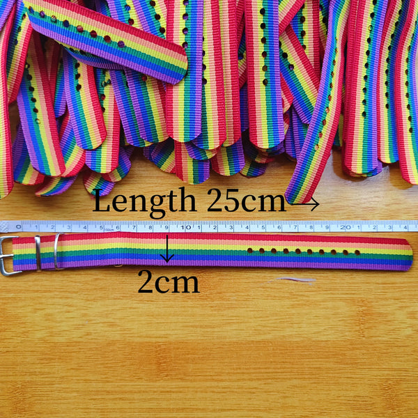 Close-up of rainbow-striped buckle bracelets with a ruler showing 25 cm length and 2 cm width