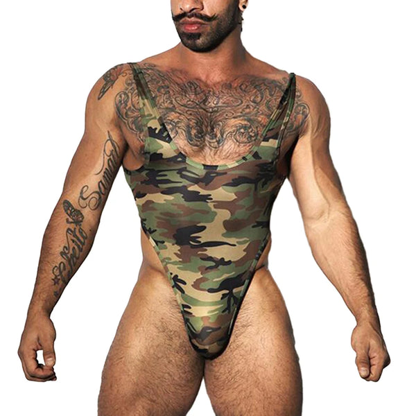 Muscled shirtless man models the Cheeky Sports Shaping Bodysuit, a camo thong swimsuit with narrow shoulder straps, deep scoop neck, accentuating tattoos and styled mustache, embodying vibrant queer self-expression and empowerment.