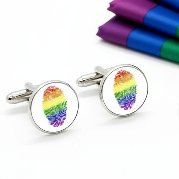 Round, silver-tone Progress Pride Thumb Cufflinks featuring vibrant rainbow fingerprint motifs, embodying LGBTQ pride. Perfect for adding a subtle, empowering touch to formal attire, celebrating identity and self-expression.