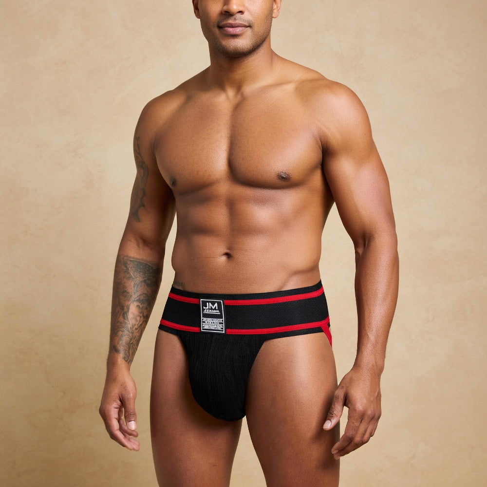 Adult model wearing a black athletic jockstrap with red edging and a rectangular front label.