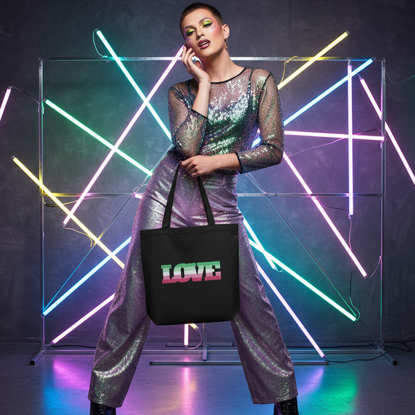 Model holds a black tote bag with pastel pink, green, and white LOVE lettering