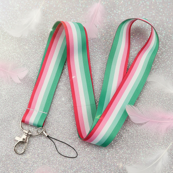 Striped green, white, and pink lanyard with a metal clasp, arranged in loops on glitter