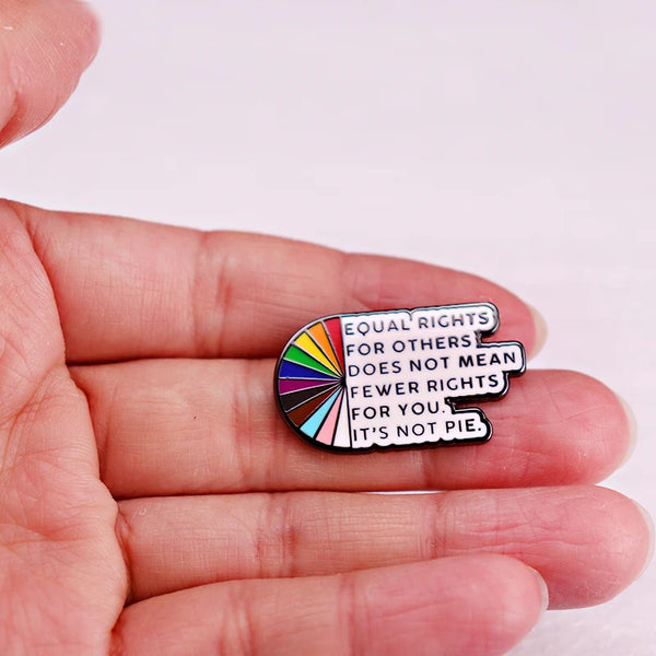 Enamel pin reading “Equal rights for others does not mean fewer rights for you. It’s not pie.”