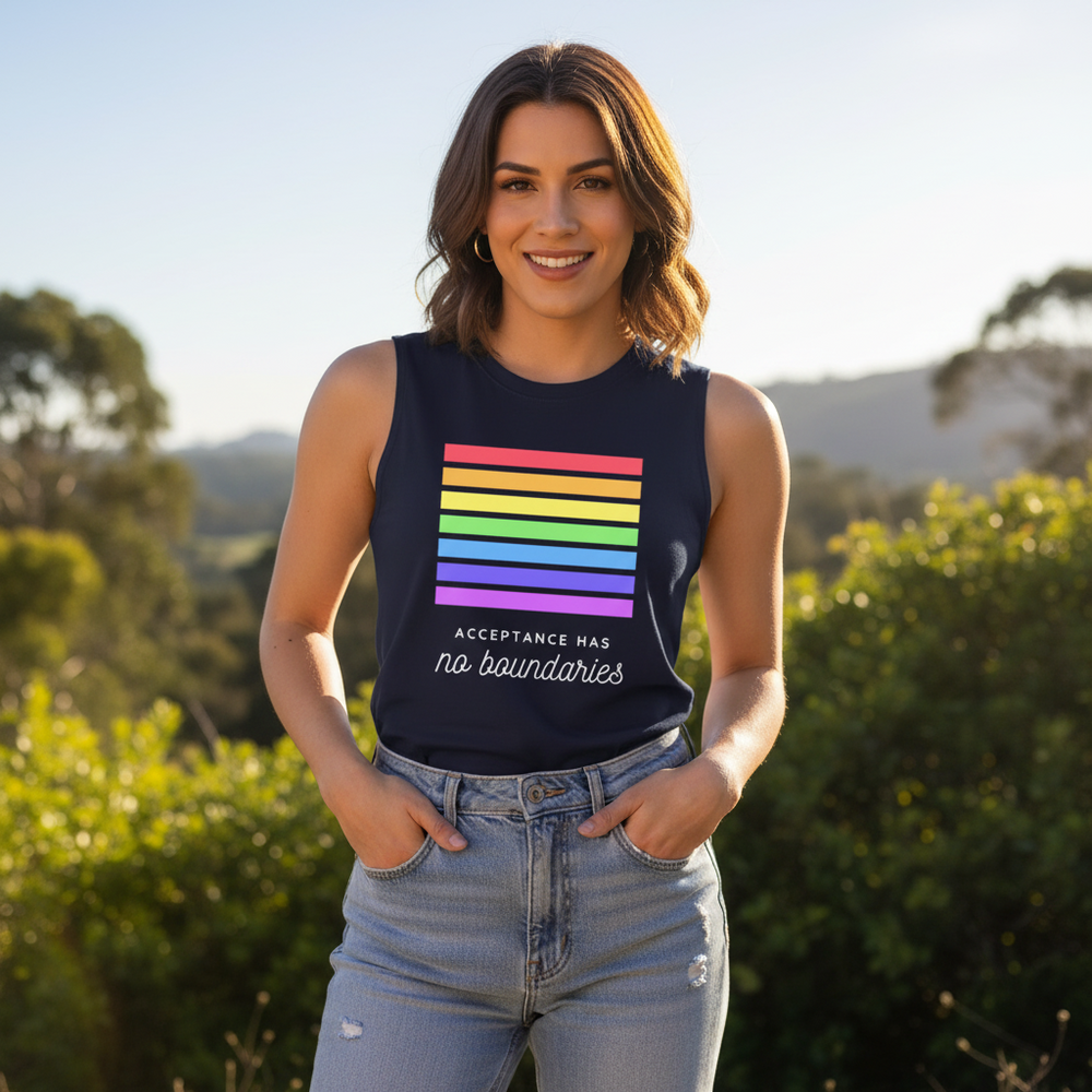 Unisex navy muscle tank with rainbow stripes and "Acceptance Has No Boundaries" slogan, worn outdoors by a smiling person