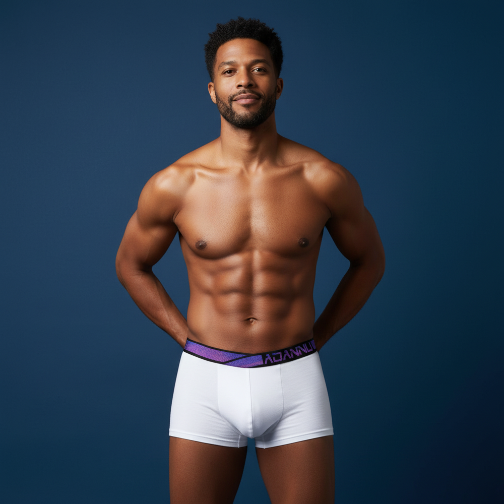 A fit person in white boxer briefs with a purple waistband poses against dark blue
