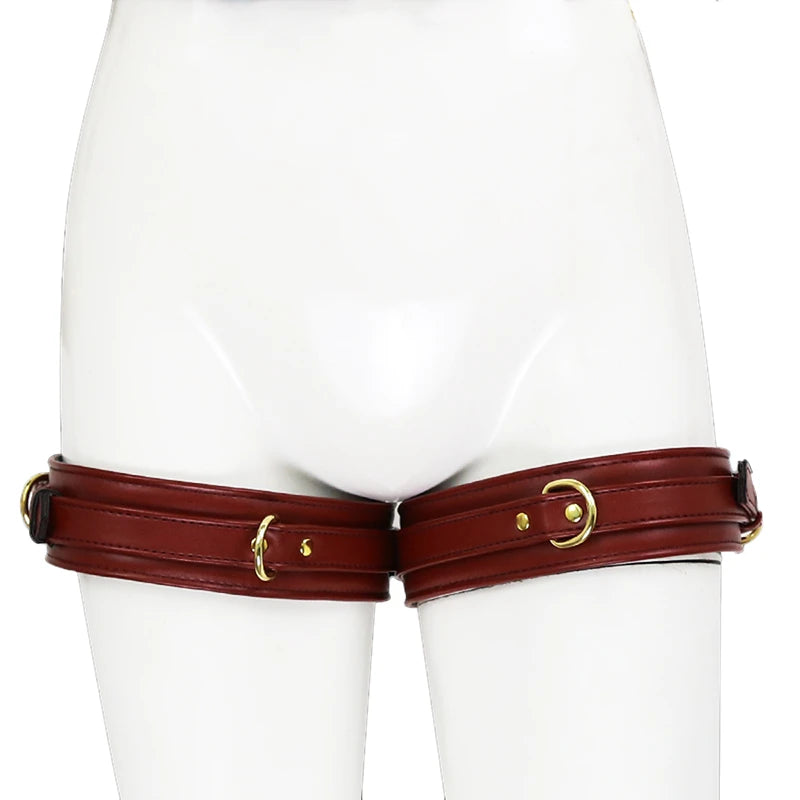 Front view of dark brown leather thigh cuffs with gold buckles on a white mannequin