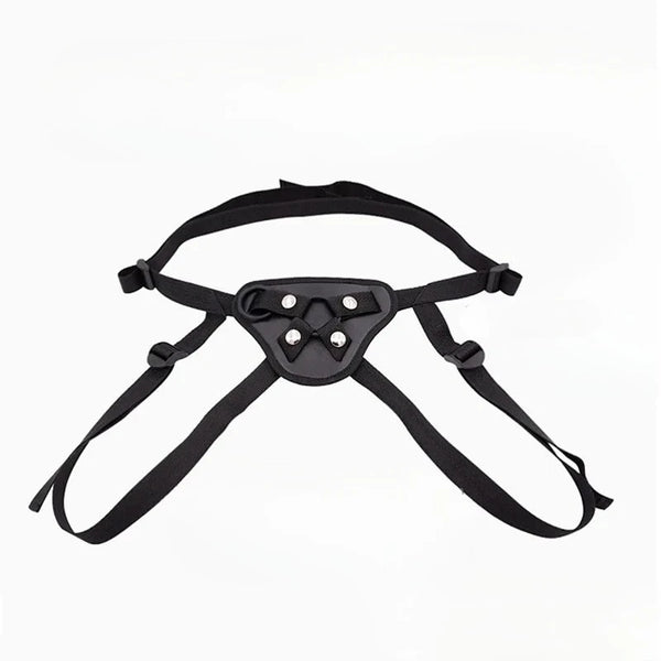 Black adjustable strap-on harness with a padded triangular front panel and four metal studs