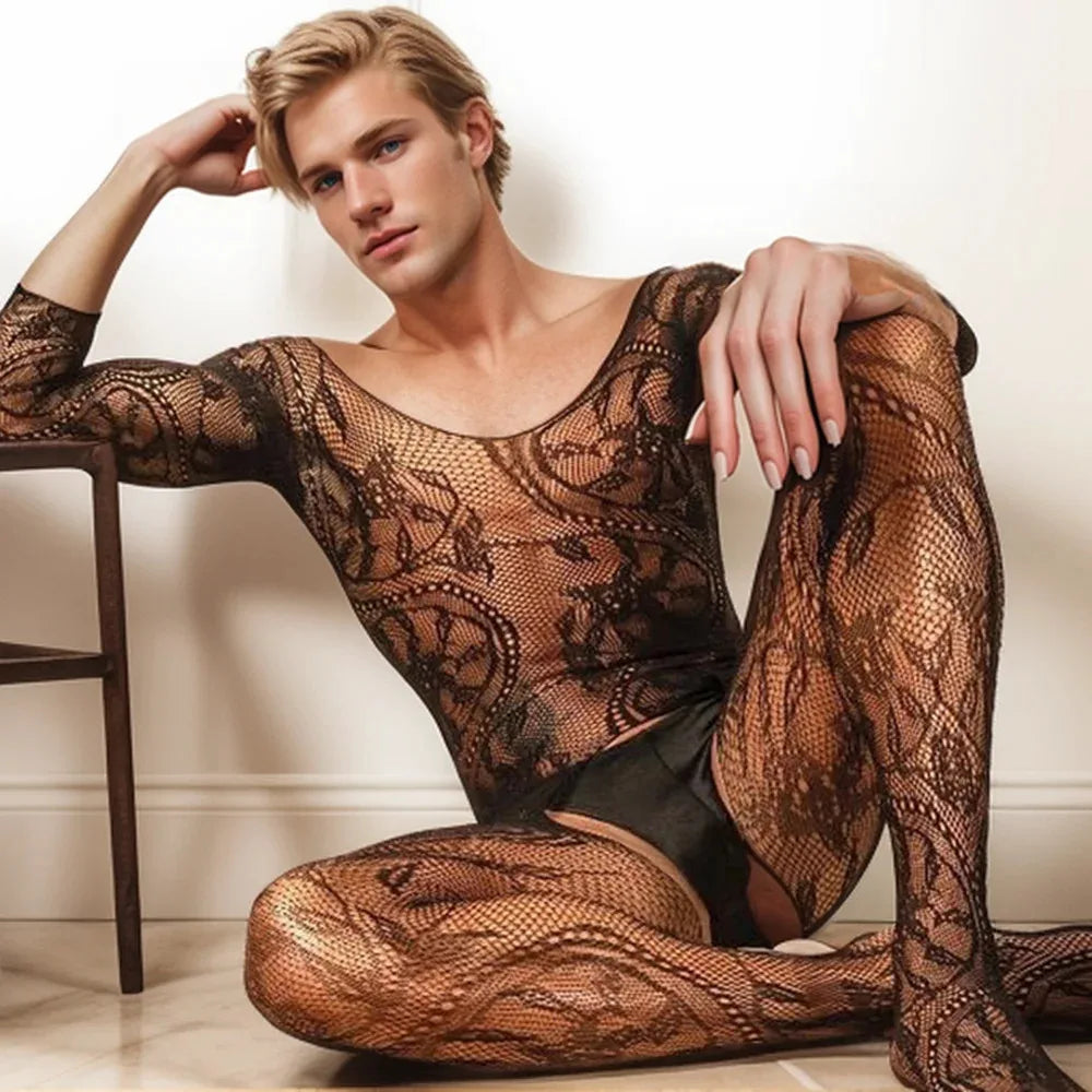 Seated model wearing a sheer black floral fishnet bodysuit with long sleeves