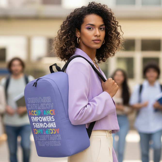 Acceptance Empowers Minimalist Backpack with "ACCEPTANCE EMPOWERS" in bold, carried by a curly-haired woman in a purple blazer and cream pants.