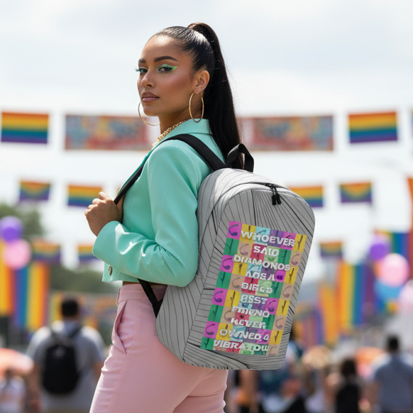 Never Owned A Vibrator Minimalist Backpack" slung over the shoulder of a vibrant femme in mint jacket, pink pants, rainbow flags fluttering.