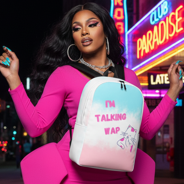 I'm Talking WAP! Minimalist Backpack" in pastel colors with a cartoon cat, carried by a femme in a bright pink dress at night.
