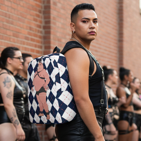 Gay Pig Minimalist Backpack slung over the shoulder of a queer person in black, posing fierce against a brick wall with friends behind.