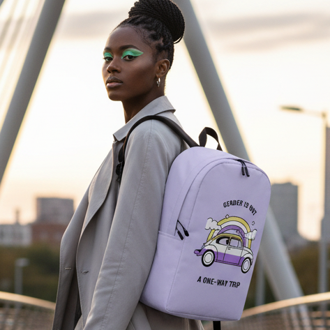 “Gender Is Not A One-Way Trip Minimalist Backpack” in hand, queer femme with braids, green eye makeup, gray trench on a sunset city bridge.