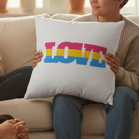 Person holding a white pillow with “LOVE” in pink, yellow, and blue stripes