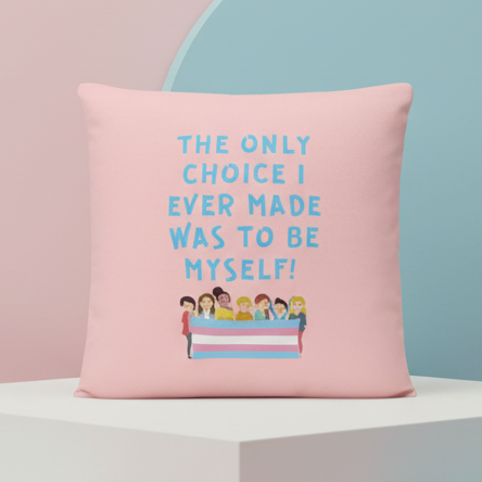 Pink pillow reading “THE ONLY CHOICE I EVER MADE WAS TO BE MYSELF!” above illustrated people and a trans flag