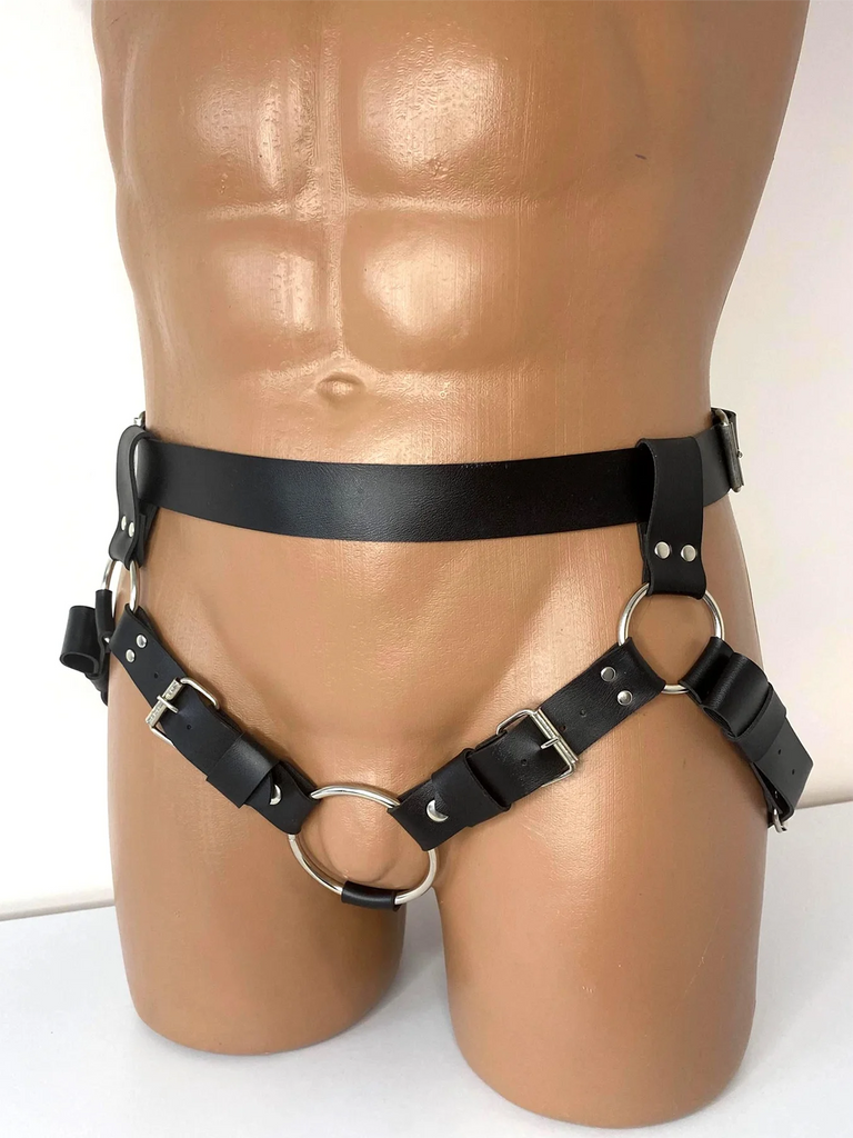Front view of a black leather bondage harness on a tan mannequin, with metal rings and buckles