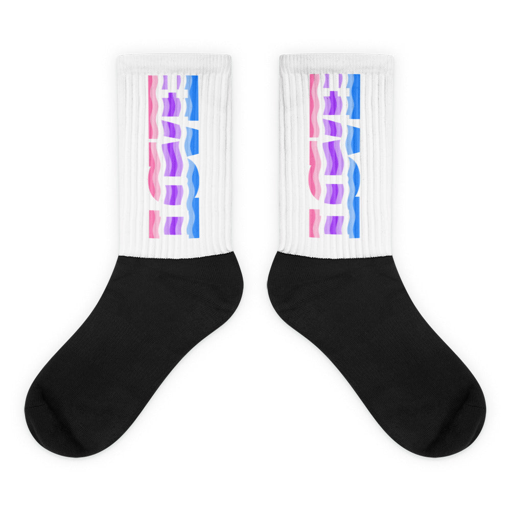 Pair of black-and-white crew socks with pink, purple, and blue abstract leg graphics