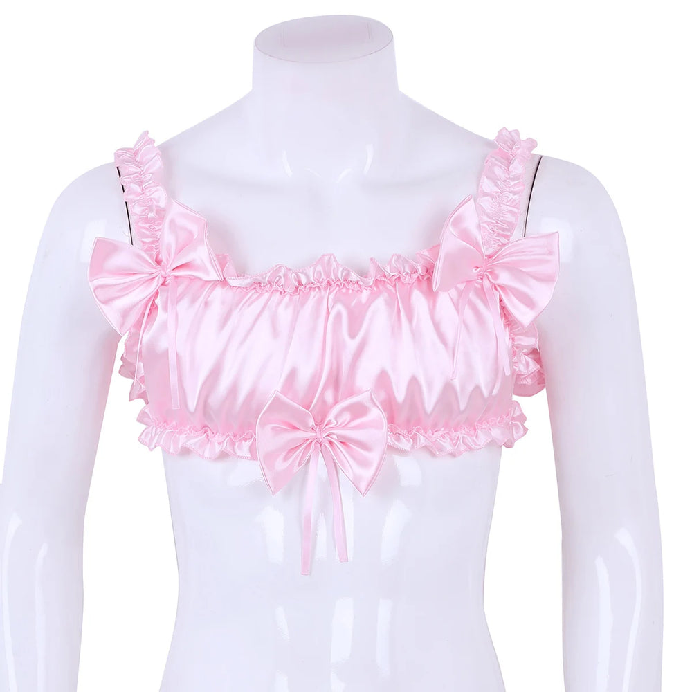 Front view of a pink satin crop top on a mannequin, with ruffles and three large bows