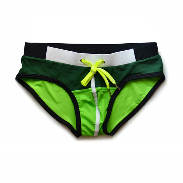 Front view of green and neon yellow color-block swim briefs with a drawstring waist