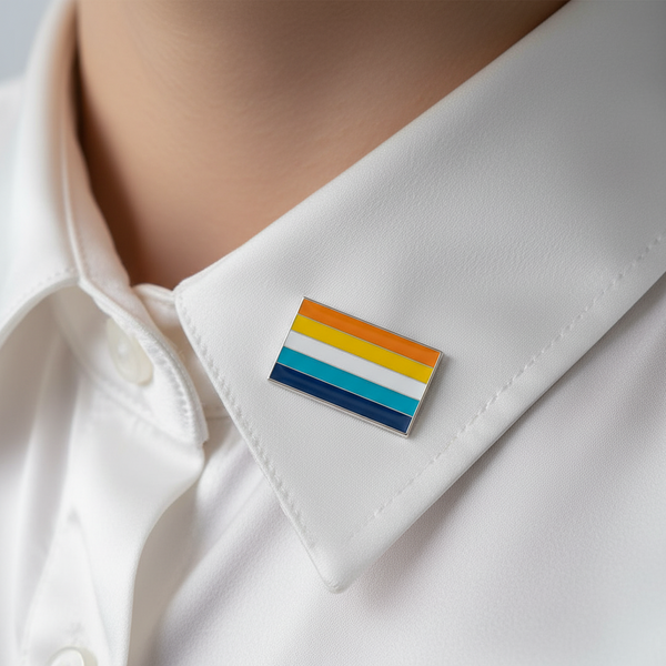Close-up of an aroace pride flag enamel pin on the cuff of a white shirt