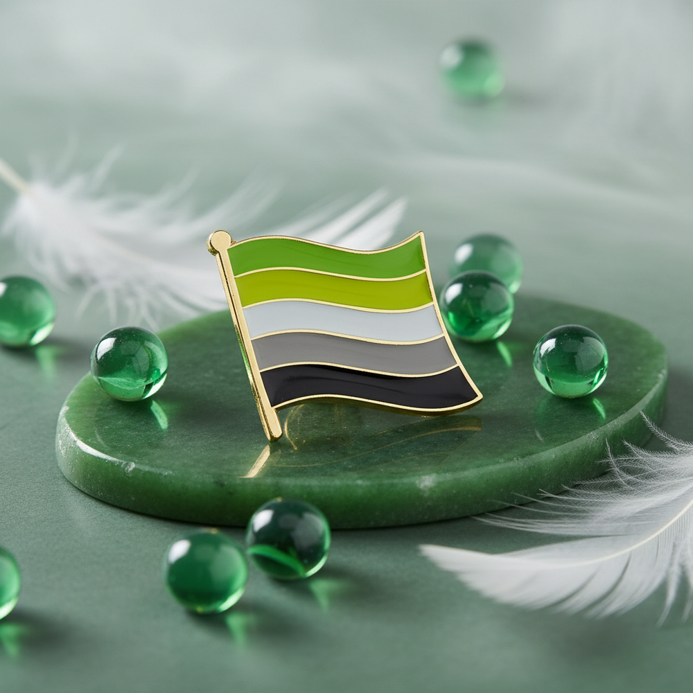 Close-up of an aromantic pride flag enamel pin with gold edging on a green display stone