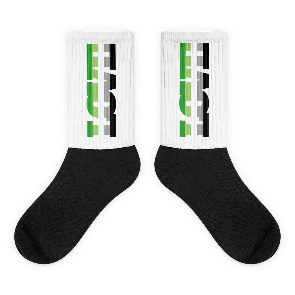 Pair of white crew socks with green, gray, and black vertical graphics and black feet