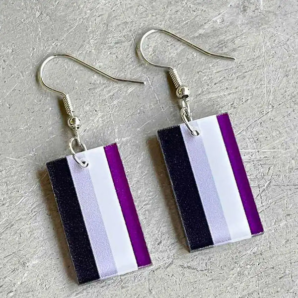 Pair of rectangular black, gray, white, and purple striped dangle earrings on a textured surface