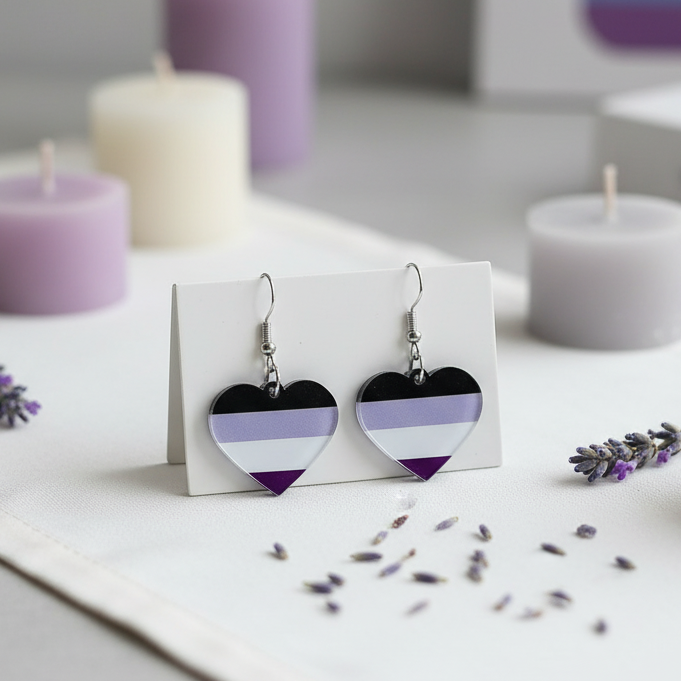 Pair of heart-shaped black, lavender, white, and purple dangle earrings on a card