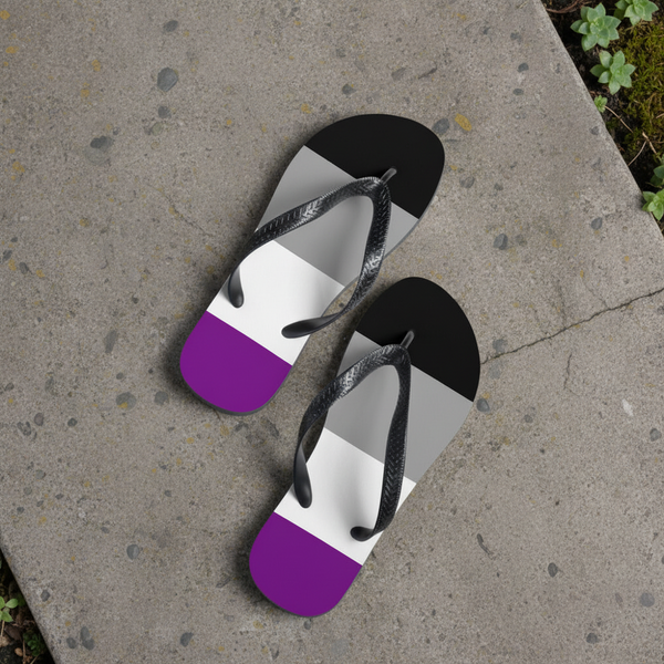 Asexual Pride flip-flops with bold black, gray, white, and purple stripes on textured concrete