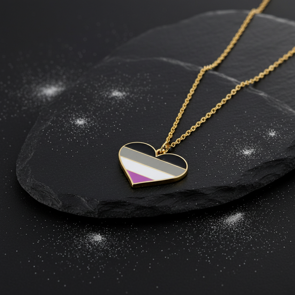 Gold chain with a heart pendant in black, gray, white, and purple enamel, shown on black slate