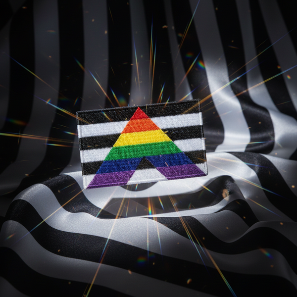 Embroidered black-and-white striped patch with a rainbow A-shaped design on draped fabric