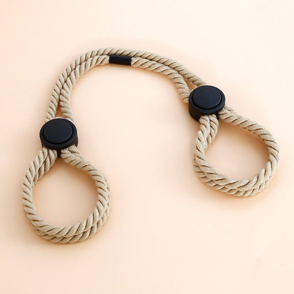 Overhead view of beige braided BDSM rope restraints with two black sliding locks