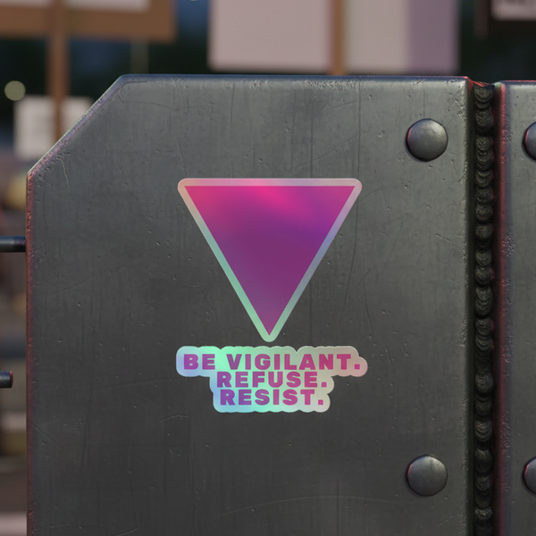 Holographic sticker on a metallic surface, with a downward-pointing triangle above BE VIGILANT. REFUSE