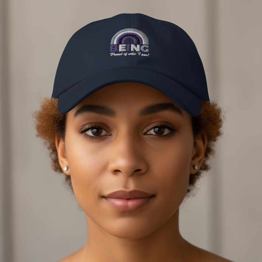 Navy blue "Being Proud Of Who I Am!" Cap with rainbow embroidery, worn by a person with warm brown skin and short curls; cozy