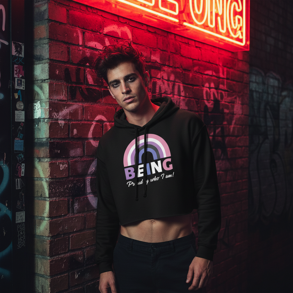 Genderfluid crop hoodie with rainbow and “Being Proud Of Who I Am!” slogan, worn by a man under red neon, graffiti backdrop.