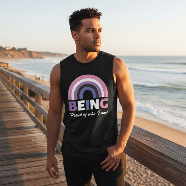 Person modeling a black muscle tank reading “BEING Proud of who I am!” on a beach boardwalk