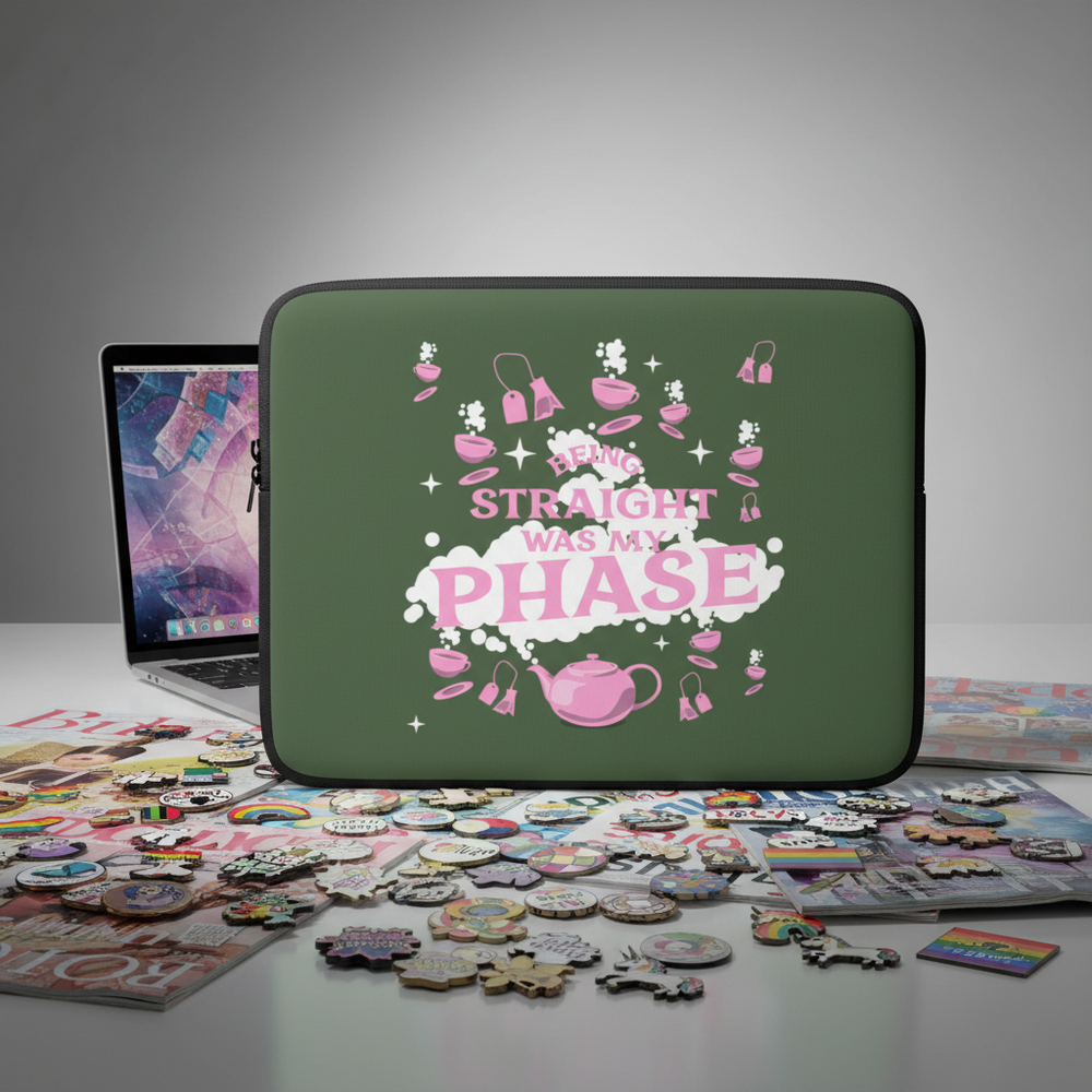 Green neoprene "Being Straight Was My Phase" laptop sleeve with pink teapot, cup, and shoe art, shown by pins and stickers.