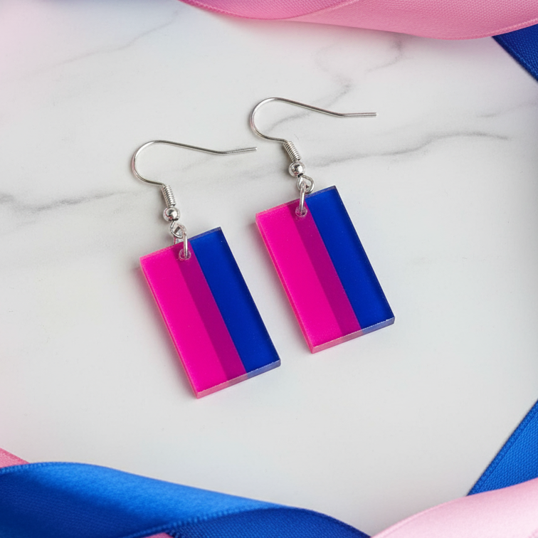 Pair of rectangular pink, purple, and blue bisexual flag acrylic dangle earrings on marble